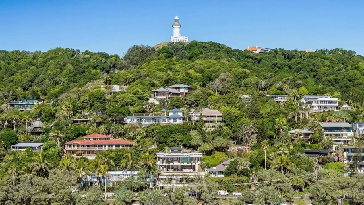A cinematic aerial frame from a Launch Studios property reel — headland homes at Byron Bay.